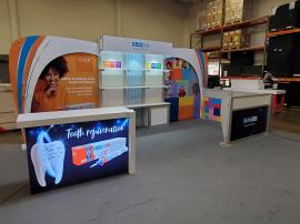 Modified ECO-2064 Sustainable Exhibit with Tension Fabric and Direct Print Graphics, Header, Acrylic Shlelves, Locking Storage, LED Lighting, Privacy Wall, Monitor Mount, and MOD-1716 Backlit Reception Counter with Locking Storage